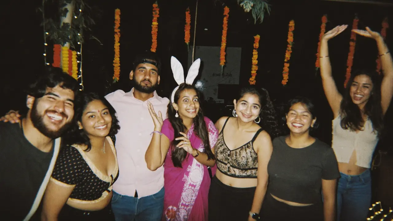 Seven friends piling into one group photo, pulling faces and bunny ears