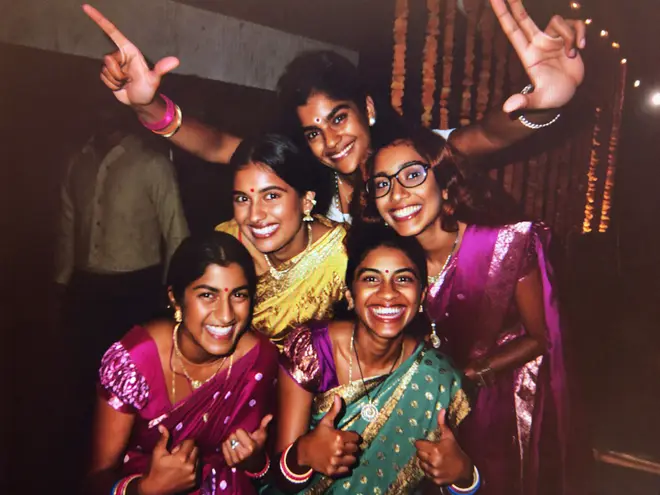 Five friends stacked into one tightly packed group photo, all laughing
